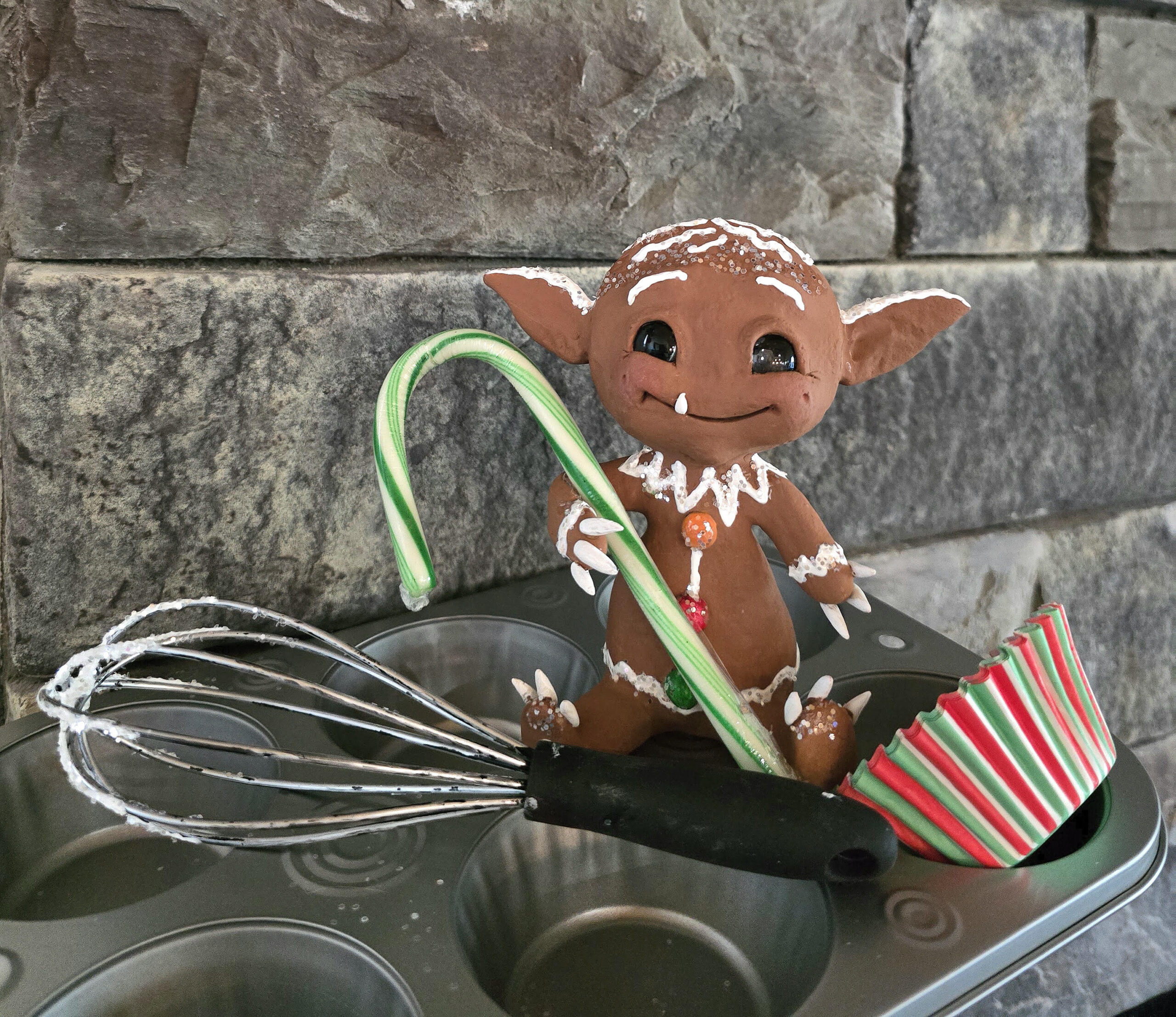 gingerbread creature with whisk and muffin tin